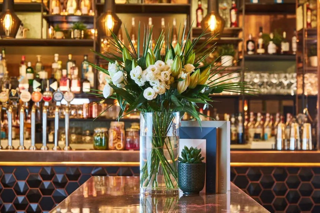 A bouquet of flowers and a vase in a nationwide pub