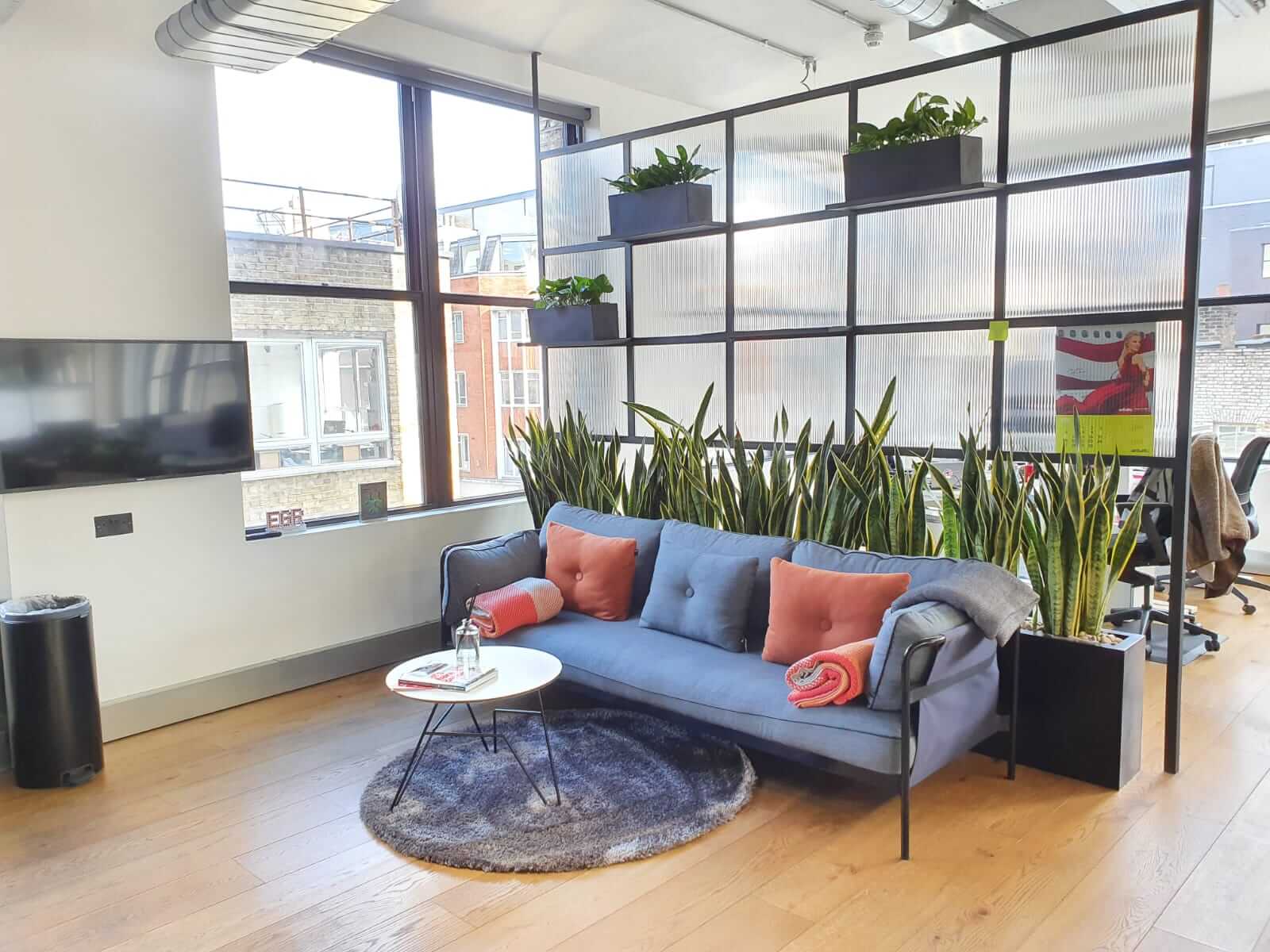 Office space with opaque room divider filled with plants
