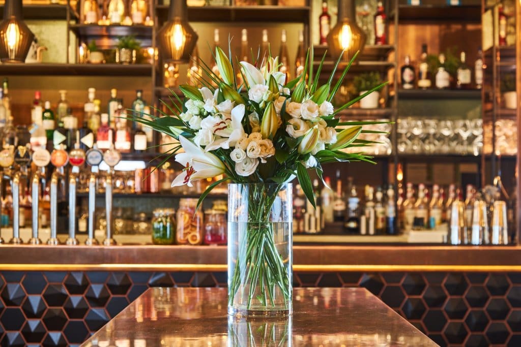 A bouquet of flowers and a vase in a nationwide pub