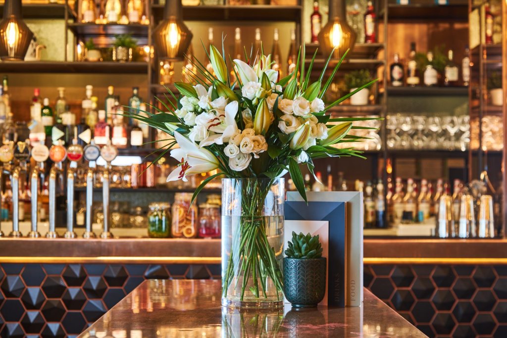 A bouquet of flowers and a vase in a nationwide pub