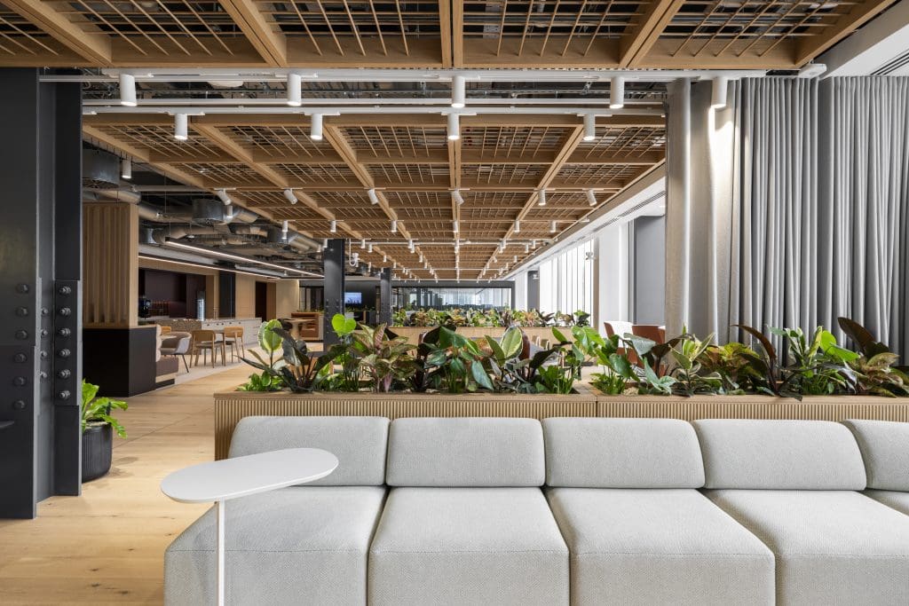 Office lounge seating with sofas, green wall, and modern décor.